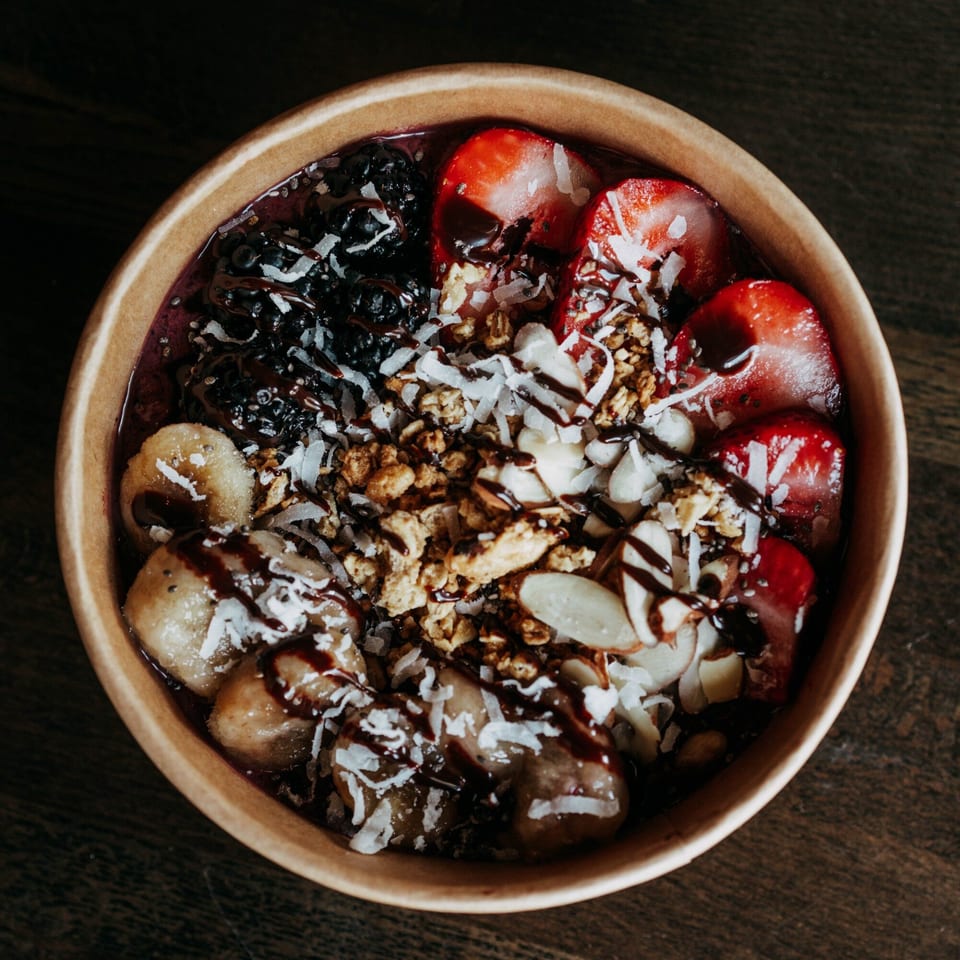 Cafe COPA's acai bowl with berries, bananas, granola, coconut, almonds, and chocolate drizzle.