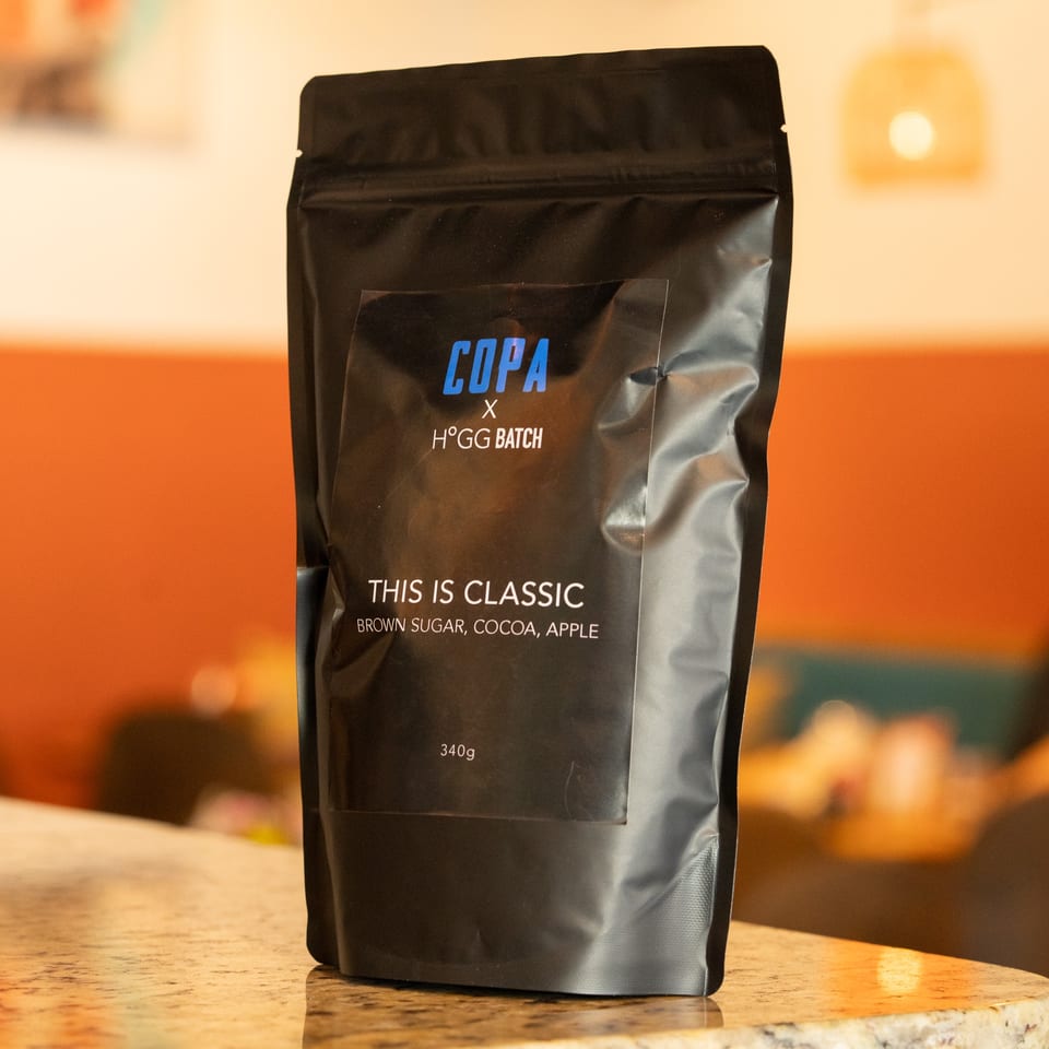 A black bag of Cafe COPA coffee beans, labeled "THIS IS CLASSIC," sits on a counter.